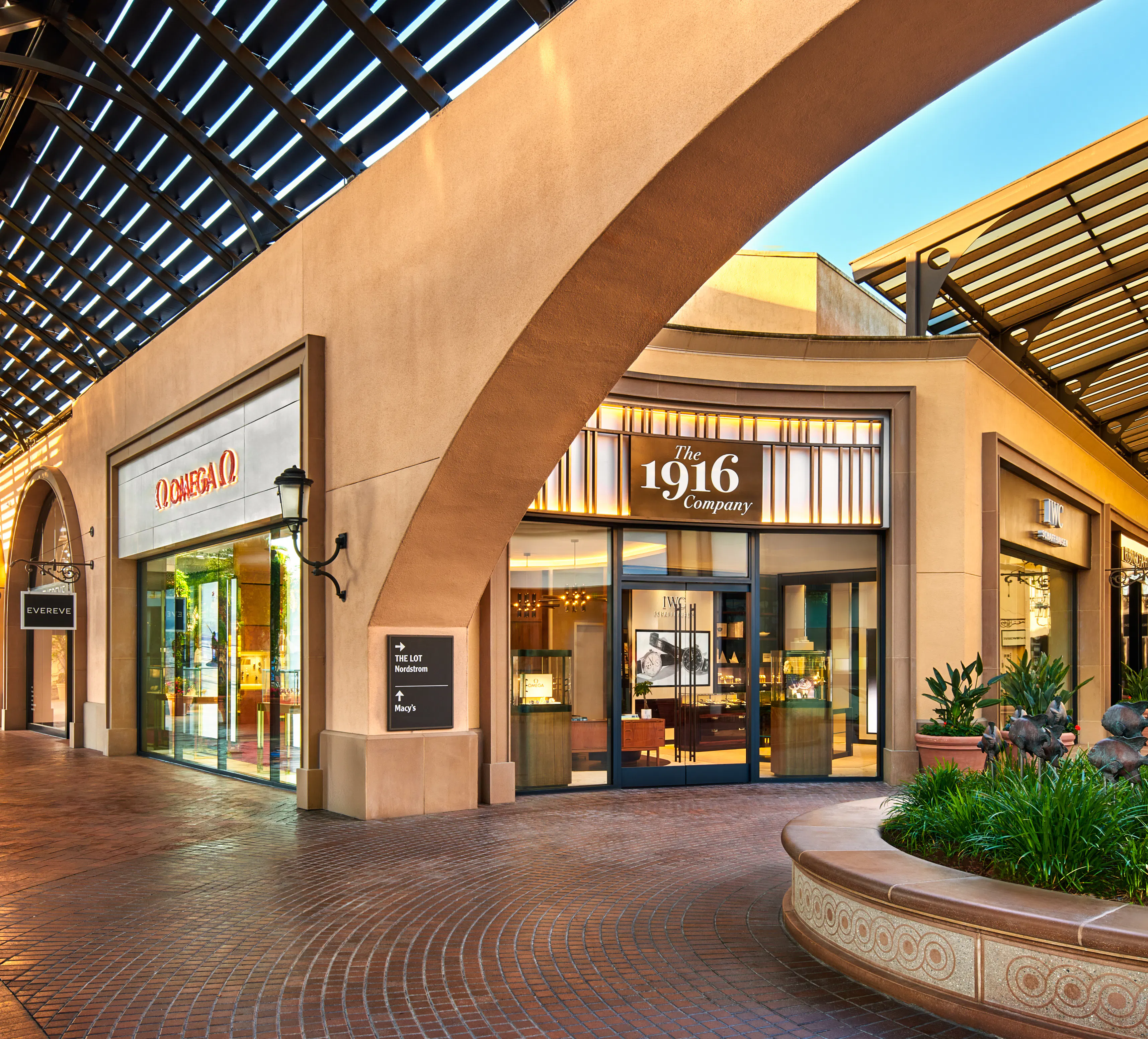 Omega and The 1916 Company boutiques at Fashion Island Newport Beach, showing storefront exterior with open-air mall walkway