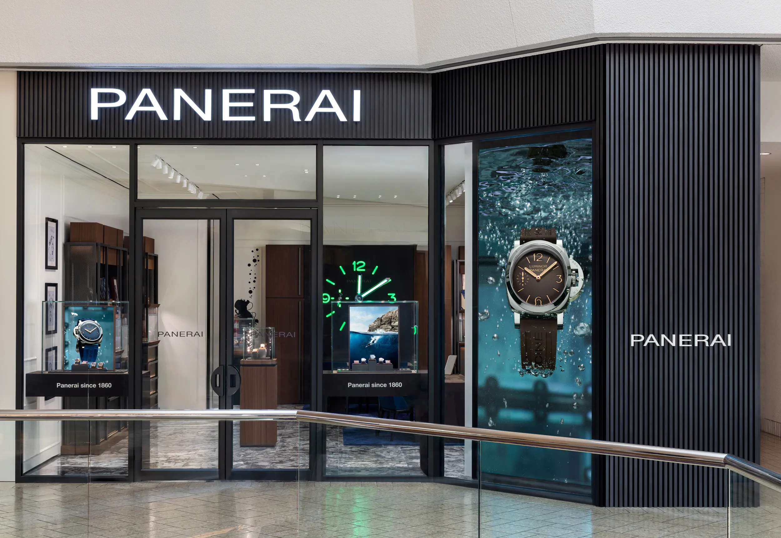 Panerai boutique interior with illuminated wall clock, seating area, and watch display cases