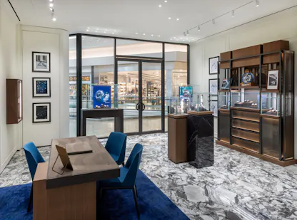 Panerai showroom interior with wood display shelving, watch cases, and Cherry Creek mall entrance view